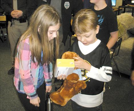 Joel and his classmate, sixth-grader Victoria Niblack, look over gifts DuMontier received.