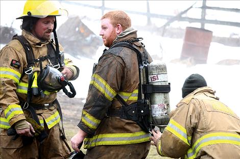 Ronan Volunteer Firefighters get their breathing apparatus replaced after exiting the smoky home,