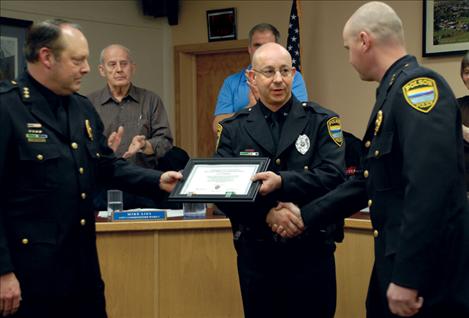 Polson Police Detective Juan Maso, center, receives a police medal and a lifesaving ribbon for rescuing a man whose boat pinned him against a rock.