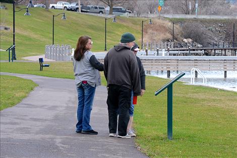 Folks stop to read one of the informative signs at Sacajawea Park Thursday afternoon.