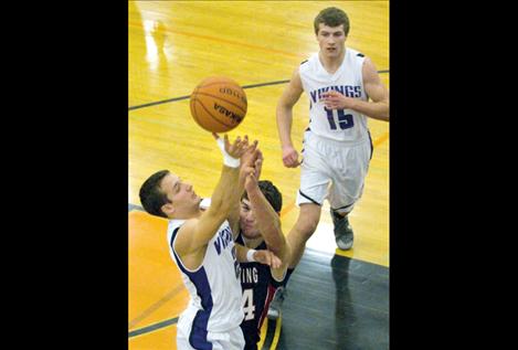 Tra Ludeman puts up a shot as Tristan Santee comes to his aid.