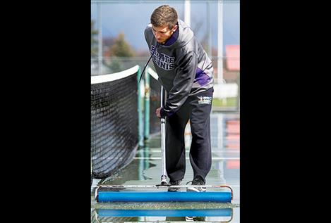 Pirates’ Jaron Morgan squeegees the cour t after a downpour.