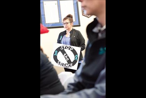 Women and men hold signs to support survivors of sexual assault during the Confederated Salish and Kootenai Tribes’ quarterly meeting.