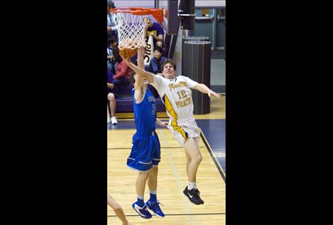 Senior Will Davey makes a layup around a Corvallis defender Feb. 8.