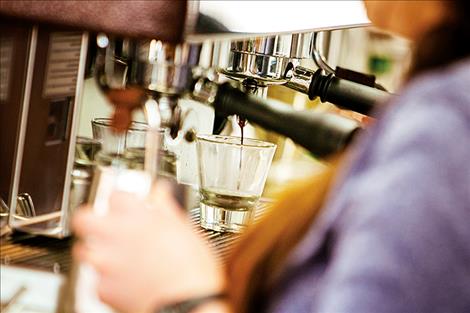 Fresh espresso  drips into a glass  before being  mixed into  a latte. 