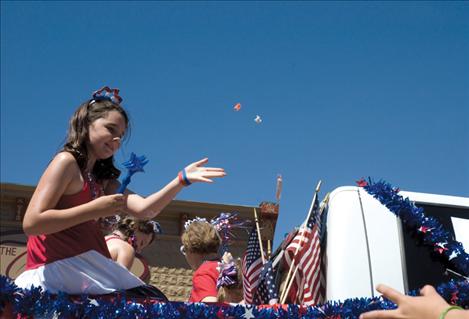 Isabel Mignone, 10, tosses candy to onlookers at the Polson Fourth of July parade.