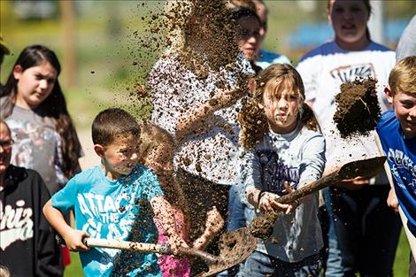 Austin Schall and Eva Cote fling some dirt during groundbreaking ceremonies.