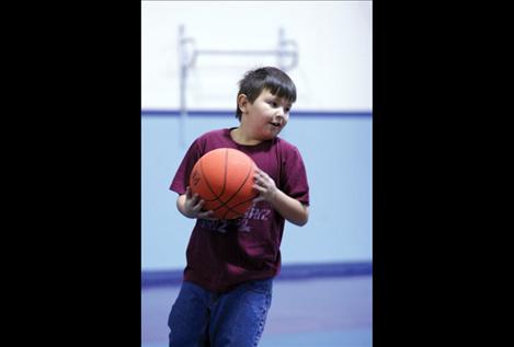 Michael Wheeler smiles while stealing a rebound from fellow Big Sky Fit Kids Club students.