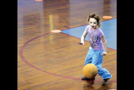 Allyson Umphrey sticks out her tongue in determination while dribbling toward the basket