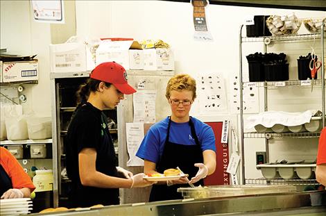 Volunteers help serve dinner to the public in St. Ignatius to bring awareness to the issues surrounding hunger.