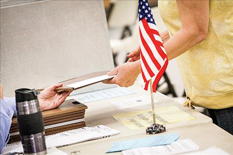Voters turn in ballots at the voting polls in Polson on Thursday.