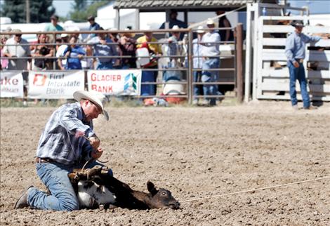 Cowboy Josh Harris ties his calf.