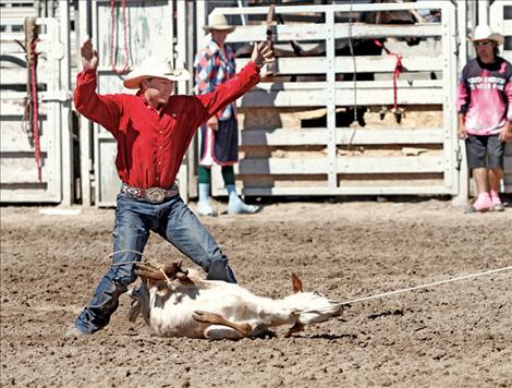 Levi Walchuk signals that his calf is tied.