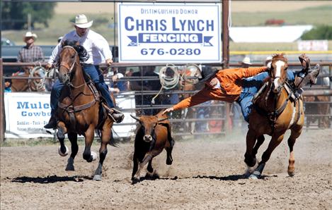 Weston Mallin leans from his horse to take down a steer.