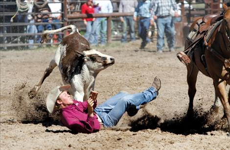2012 Montana state high school steer wrestling champion Will Powell hits the dirt as his steer steers clear of the incoming cowboy. 