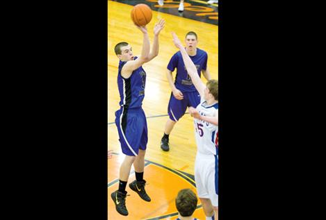 Senior Hayden Congdon shoots for two as Will Davey watches during Polson’s game against Columbia Falls Friday.