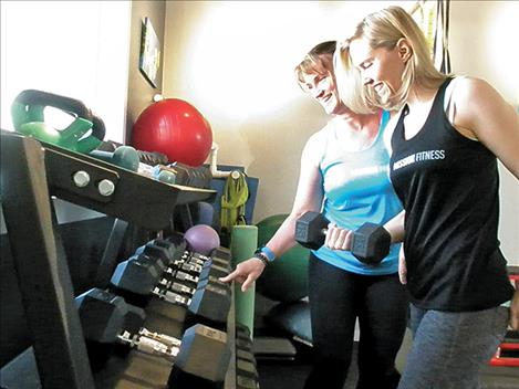 Trainers Karla Gallatin and Angela Hisel arrange some of the free weights.