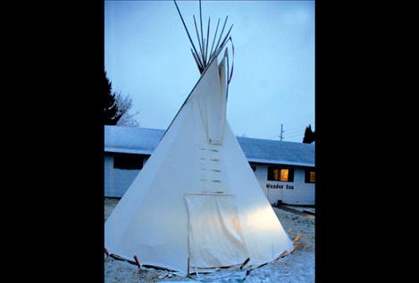 Light from the stove and lantern shines through the walls of the teepee. To raise awareness of homelessness, people are spending the night in the teepee to raise money for renovations on a homeless shelter.