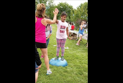Aleiha Walbeck gets a high five for finding her balance on a bosu balance trainer. Students were provided with various health information or tips for staying active from 21 vendors at the health fair portion of Linderman’s end of year event.
