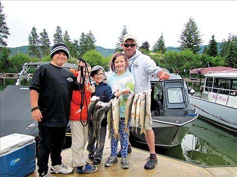 Boat captain Matt McComb and happy young anglers hold up a stringer of lake trout at the Jerry Howard Fishing Without Barriers Day on June 15. The event was held on the east shore of Flathead Lake with the help of 16 boat captains.
