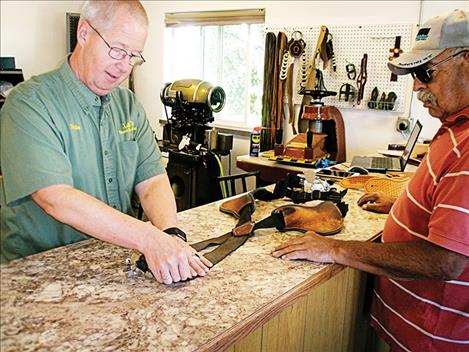 Dale Lane and Ronan resident Butch Berland talk about some carpet belt suspenders Berland brought in for repair. 