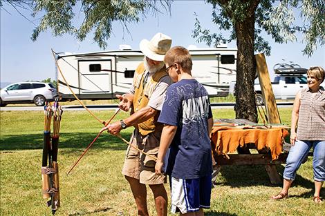 Gary Steele teaches Eithan McCauley how to shoot a traditional longbow.