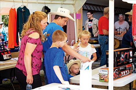 Nate, Amanda, Brody, Bailey and Boyd Smith look at a toy truck being sold as part of the silent auction to help raise money for the Arlee Volunteer Fire Department. In past years the department has raised as much as $7,000 between the auction and pancake feed. 
