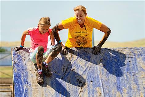 Mother Barbara Jean and daughter Tatyana Dupuis battle the wall obstacle.