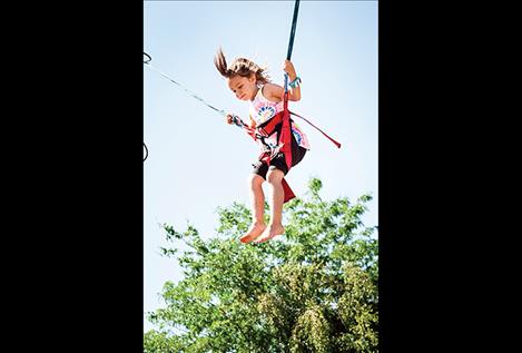 An air bound bouncer enjoys some high flying fun at the cherry festival.