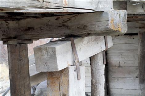 A rusted steel band precariously holds timbers in place under the bridge.