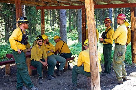 A fire crew in from South Carolina takes a break while waiting for their next orders. Fire crews from as far as Canada and New Mexico are also on site. 