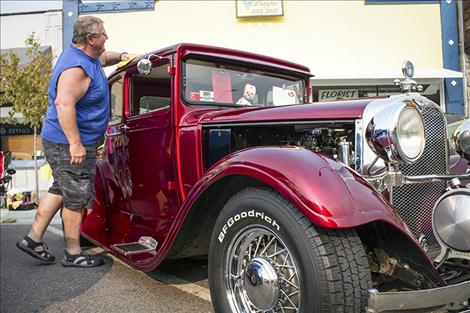 Paul Kruger puts a last minute wax on his 1928 Dodge as car show patrons start to show up.