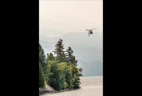 A Chinook (CH-47D) helicopter scoops water from Blue Bay on Friday morning. It has a capacity of carrying 1500 gallons of water with a 4 minute turn-around time to the blaze east of the Flathead Lake. 