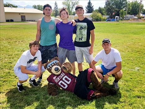 Charlo High School seniors Tyson Petticrew, Chandler Krahn, Sabin Perry, Shad Anderson and Brady Fryberger pose for a photo with UM mascot Monte Bear.
