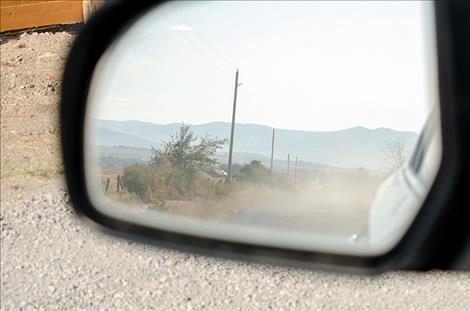 Karen Peterson/Valley Journal Dust fills the air on a dirt road near St. Ignatius from a slow moving car.