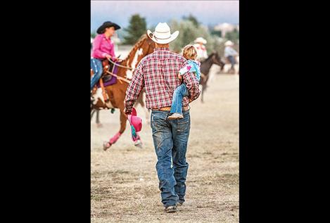 Collin Johnson walks with his tiny tot, Harlee Johnson after her barrel racing. 