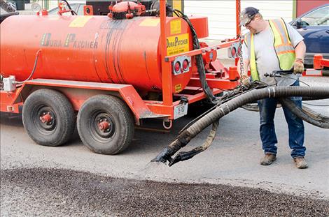 Dan Miller fills potholes on Fourth Avenue SW in Ronan.