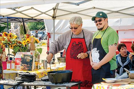 Larry Hall and Eric Hall, father and son, stir up a batch of chicken. 