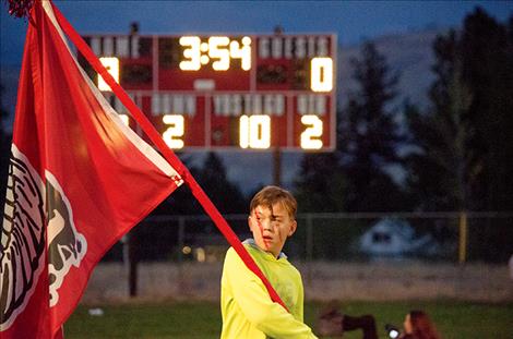 Edwin Koetter, 11, carries the Arlee flag during the football game.