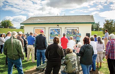 Community members gather on Sunday to dedicate a tile mosaic at Riverside Park.