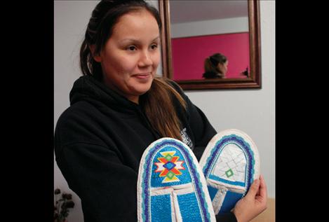 Randi Auld displays some moccasins she is beading using tri-cuts from Dacia Whitworth’s shop.