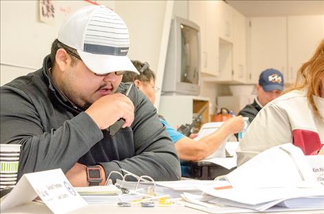 Gerald Trombley, from Lake County, works on  taking calls with a handheld radio during a mock  large-scale emergency  created by the training crew.