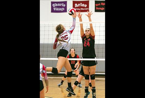 Ashley Revis taps one over the net. Left: Coach Lonnie Morin prepares the girls for the next set.