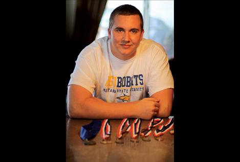 Riley Sampson, donning his new Montana State University T-shirt, poses with an assortment of his medals.