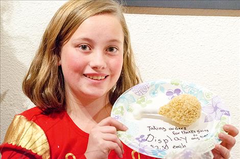Elina Moore, 13, displays a rice cereal and marshmallow treat in the shape of a turkey drumstick. She is taking orders for her specialty holiday treats.