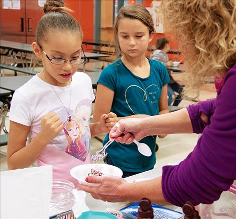 A variety of ice cream toppings including sprinkles completed children’s sundaes.