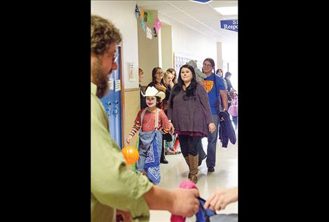 Children and parents walk the halls of the high school to collect treats and see the costumes.