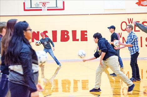 Students learn to play Gaelic football in the gym.