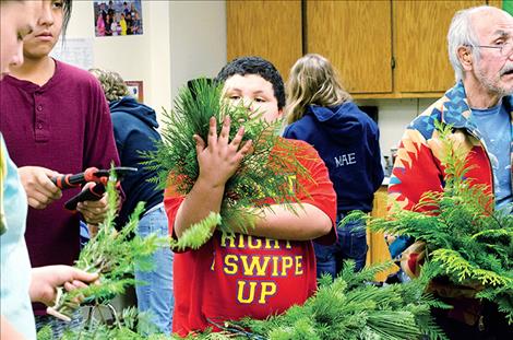 Karen Peterson/Valley Journal Jayden Simmons, 10, measures out the greens with his arm to make a wreath. 