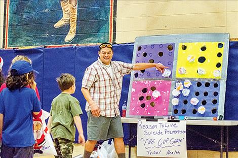 Brandon Burke mans the Tribal Health cup game at the holiday carnival. In order to receive the prize in the cup, participants had to throw bean bag balls into a paper-covered cup. Consolation candy was given out if they didn’t make the shot. Santa Claus, below, came by to hear what kids want for Christmas.